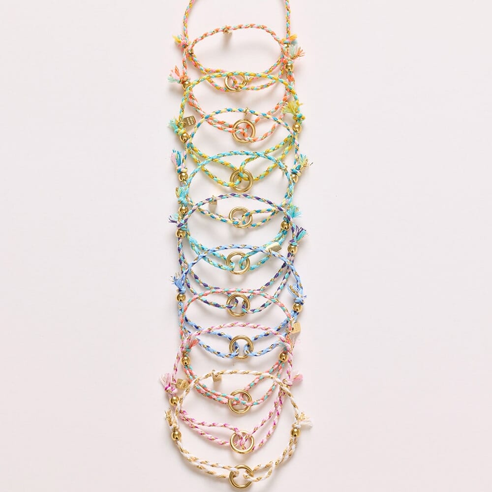 Set of colorful bracelets on a light pink background