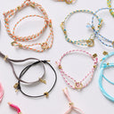 Collection of colorful bracelets with small charms on a light background
